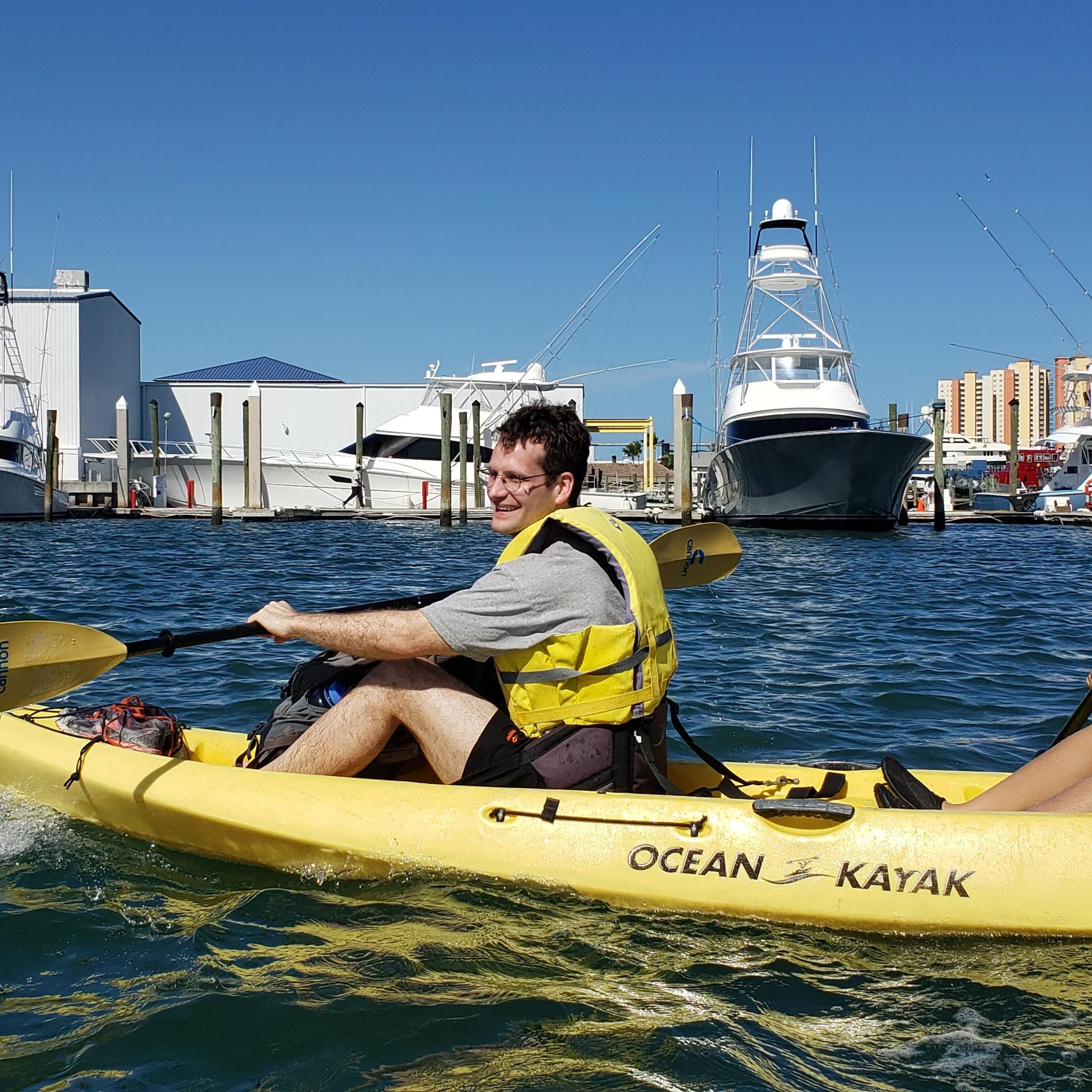 Doug and Bianca paddle in a double kayak on the ocean