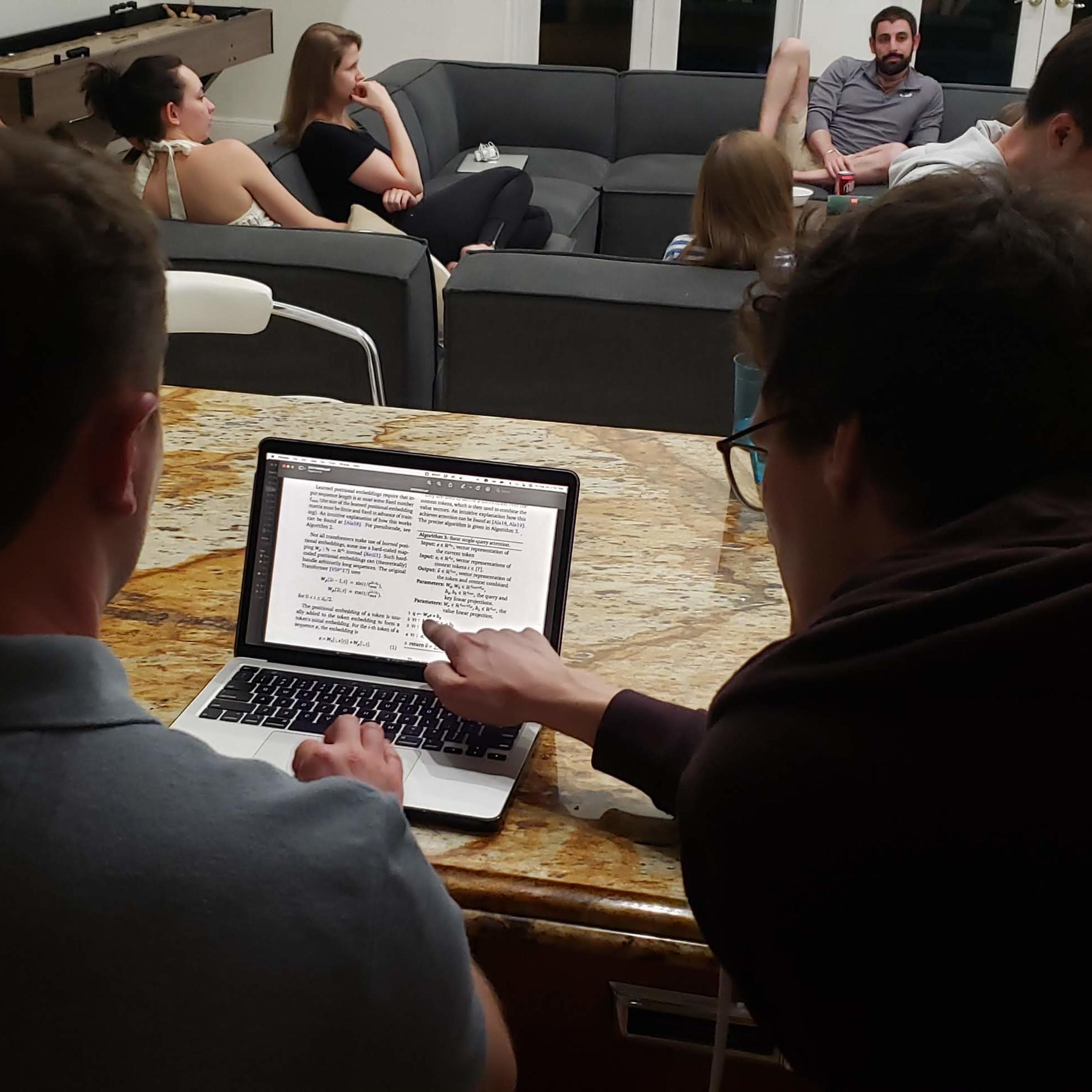 Dominik and Benedikt discussing a paper on a laptop