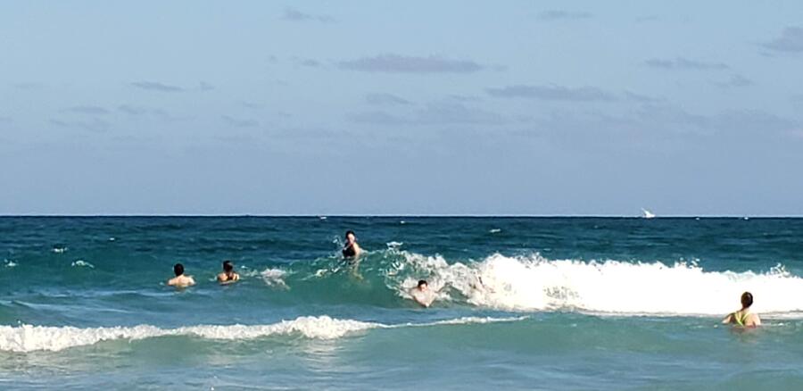 a group jumps waves in the ocean